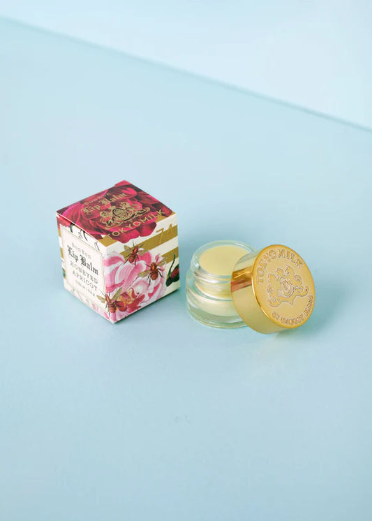 Tinted lip balm by TokyoMilk, alongside its box, featuring floral and bee illustrations.
